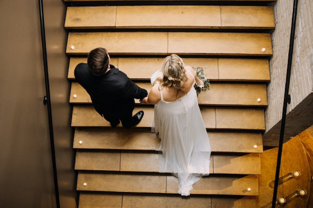 Couple walking up a staircase at their wedding at FIVE Event Center